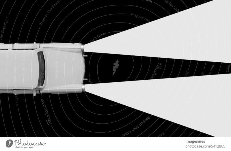 Retro Auto Spielzeug Modell und Xenonlampen Scheinwerfer Konzept. Schwarz-weißer Hintergrund. Mieten Sie ein Auto, Reiseunfall, Versicherungskauf, minimales Konzept