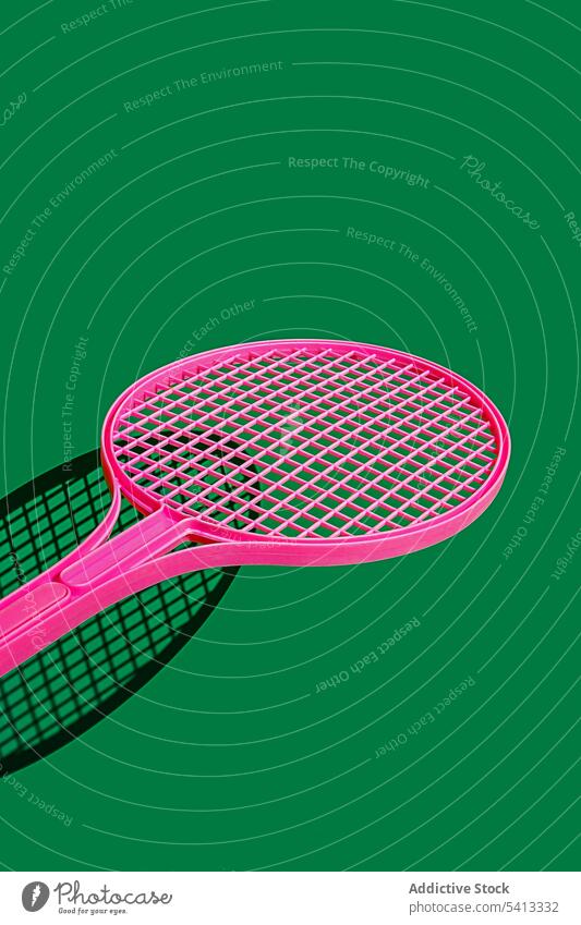 Rosa Tennisschläger auf grünem Untergrund Remmidemmi trendy Farbe Sport Gerät kreativ Stil hell Hobby Kulisse Design Objekt farbenfroh Zeitgenosse Kunst