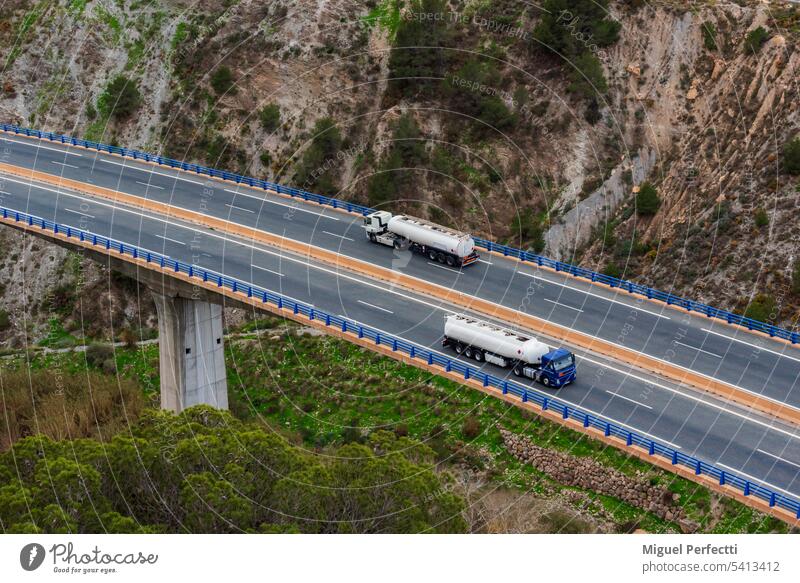 Zwei Tanklastzüge überqueren eine Autobahn über eine Brücke, Luftaufnahme. Lastwagen Verkehr brennbar Brennstoff Benzin Viadukt Diesel logistisch Verteilung