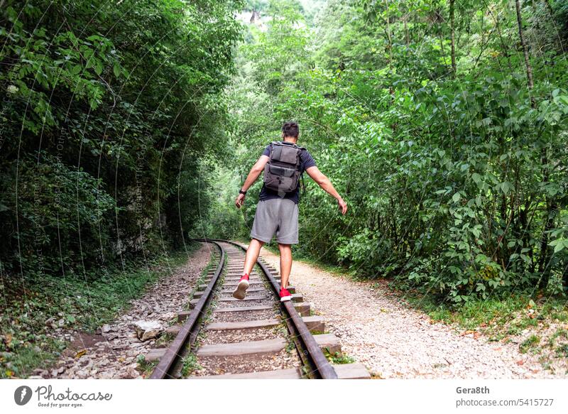 junger männlicher Tourist läuft auf der Eisenbahn im thailändischen Dschungel Abenteuer Rucksack Klima Fitness Wald Freiheit frisch gehen Sie grün Gesundheit