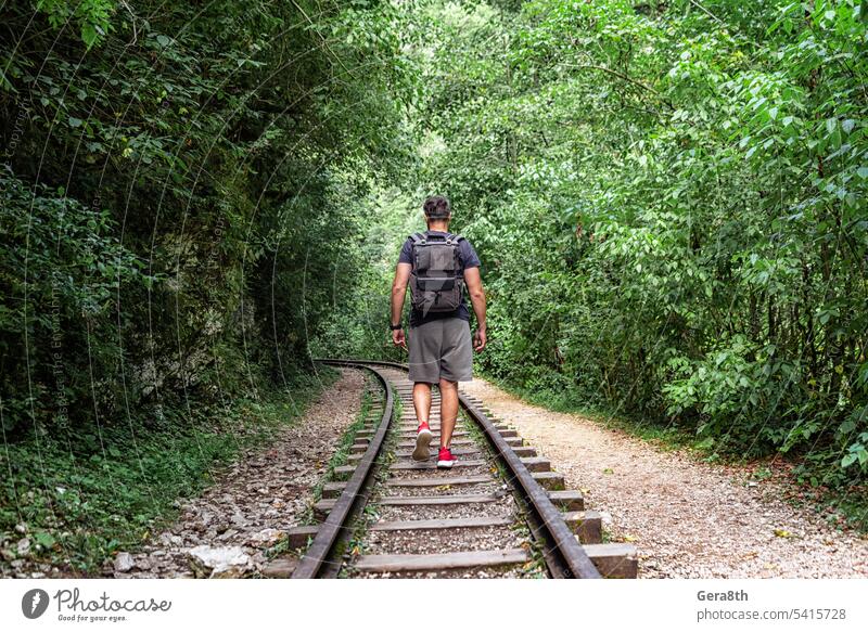 junger männlicher Tourist läuft auf der Eisenbahn im thailändischen Dschungel Abenteuer Rucksack Klima Fitness Wald Freiheit frisch gehen Sie grün Gesundheit