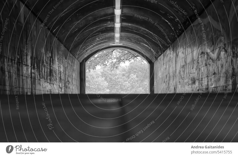 Blick aus einem Tunnel heraus, Licht am Ende des Tunnels, schwarz-weiß, horizontal Fußgängertunnel niemand menschenleer grau Graffiti urban städtisch hinaus