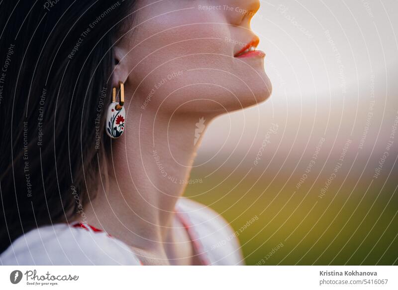 Junge Frau mit ethnischen Ohrring und Hemd mit traditionellen Ornamenten Atem frei attraktiv Perlen schön Schönheit Blüte Stoff gestickt Stoffbeschaffenheit