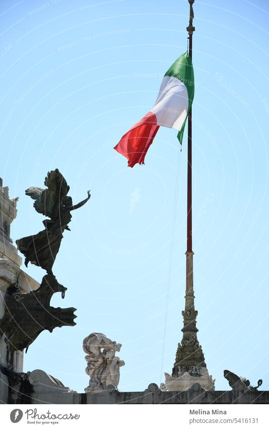 Italienische Flagge auf blauem Himmel mit einer Engelsstatue Fahne rot-weiß-grüne Fahne Blauer Himmel Flagge im Hintergrund italienische architektur Statue