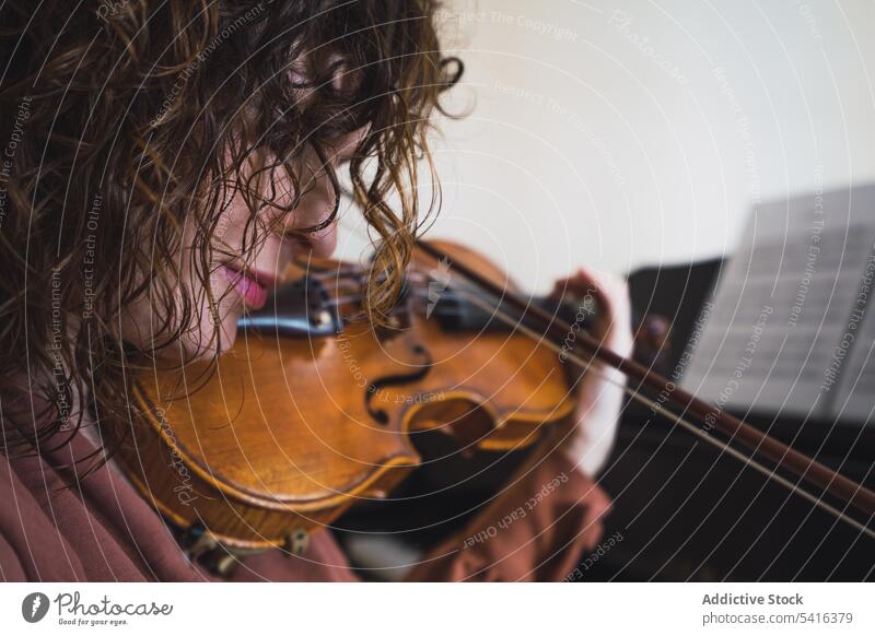 Schwangere Frau spielt auf Geige in der Nähe von Klavier im Zimmer schwanger Musiker Spielen Raum attraktiv jung krause Haare schön geschlossene Augen Bauch