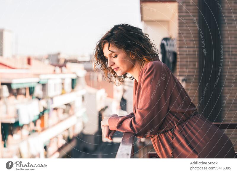 Attraktive Frau auf Balkon attraktiv jung krause Haare schön Großstadt urban positiv Lifestyle sich[Akk] entspannen lässig Freizeit Sommer heimwärts elegant