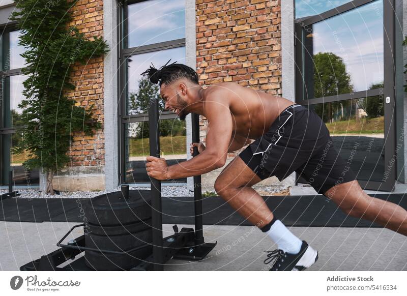 Schwarzer Mann zieht Gewichte in einem Fitnessstudio im Freien ziehend Sport Afroamerikaner Athlet Training männlich schwarz ethnisch Gerät Gebäude Außenseite