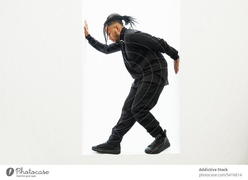 Tanzender ethnischer Mann mit Zöpfen Afroamerikaner Hiphop Tänzer Rap geflochten Behaarung jung männlich Person gutaussehend aktiv trendy stylisch energetisch