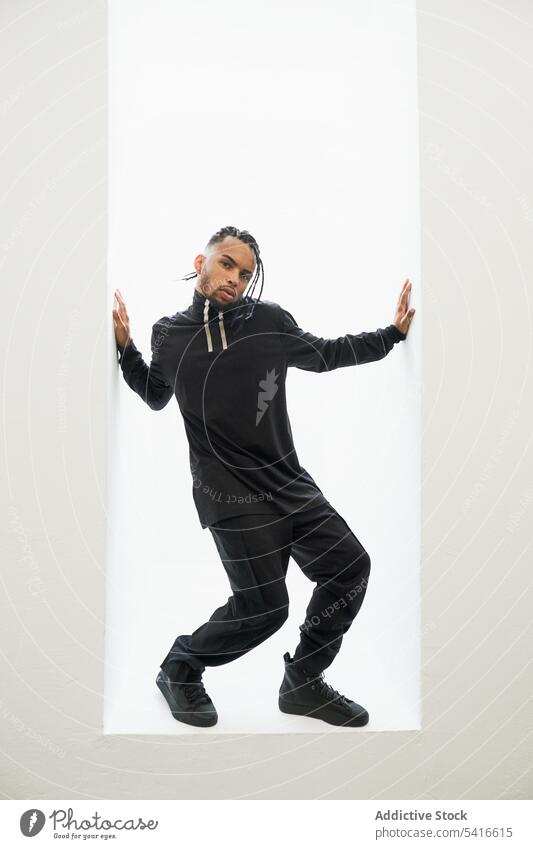 Tanzender ethnischer Mann mit Zöpfen Afroamerikaner Hiphop Tänzer Rap geflochten Behaarung jung männlich Person gutaussehend aktiv trendy stylisch energetisch