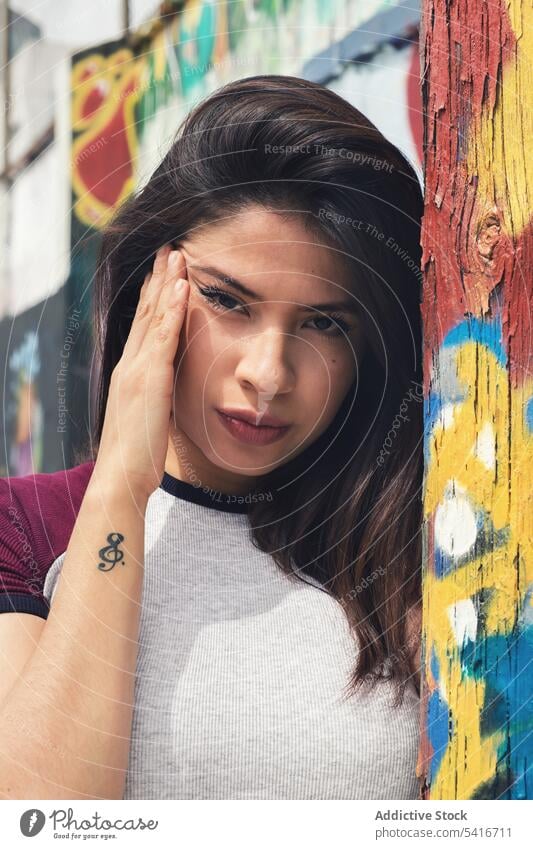 Frau steht in der Nähe einer Graffiti-Wand hübsch jung schön Konzept Stil Baustein urban Großstadt brünett attraktiv Person Schönheit Erwachsener niedlich