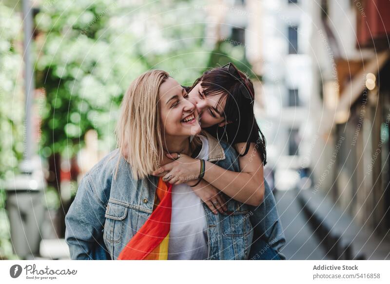 Glückliches lesbisches Paar hat Spaß auf der Straße lgbt umarmend Heben Huckepack Großstadt jung Zusammensein Frauen lässig Homosexualität Stolz Runde