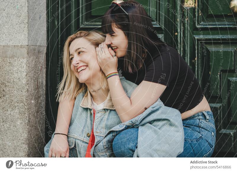 Lesbisches Paar sitzt in der Nähe der Tür Gefühle Glück Lächeln umarmend Stadt schön alternativ Zusammensein Homosexualität Frauen Lifestyle Partnerschaft
