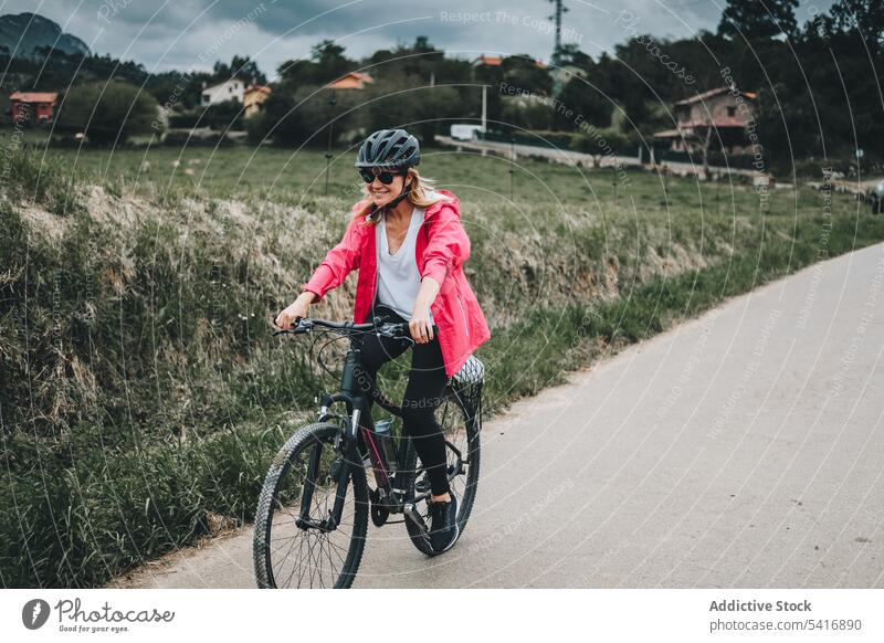 Lächelnde Frau auf dem Fahrrad Reiten Straße jung Person heiter aktiv sportlich Radfahrer genießend Lifestyle reisen Verkehr Abenteuer Schutzhelm Sonnenbrille