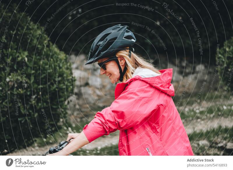 Lächelnde Frau auf dem Fahrrad Reiten Straße jung Person heiter aktiv sportlich Radfahrer genießend Lifestyle reisen Verkehr Abenteuer Schutzhelm Sonnenbrille