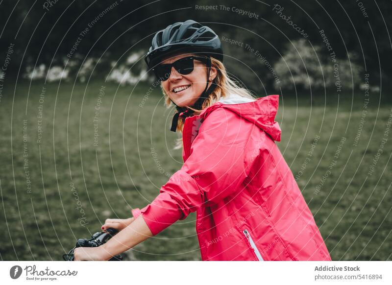 Lächelnde Frau auf dem Fahrrad Reiten in die Kamera schauen Straße jung Person heiter aktiv sportlich Radfahrer genießend Lifestyle reisen Verkehr Abenteuer