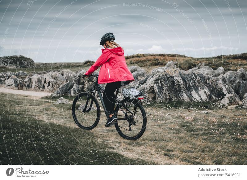 Radfahrerin fährt auf einer Bergstraße Frau Fahrrad Reiten Straße Schutzhelm felsig Berge u. Gebirge Landschaft Erwachsener Person aktiv sportlich allein