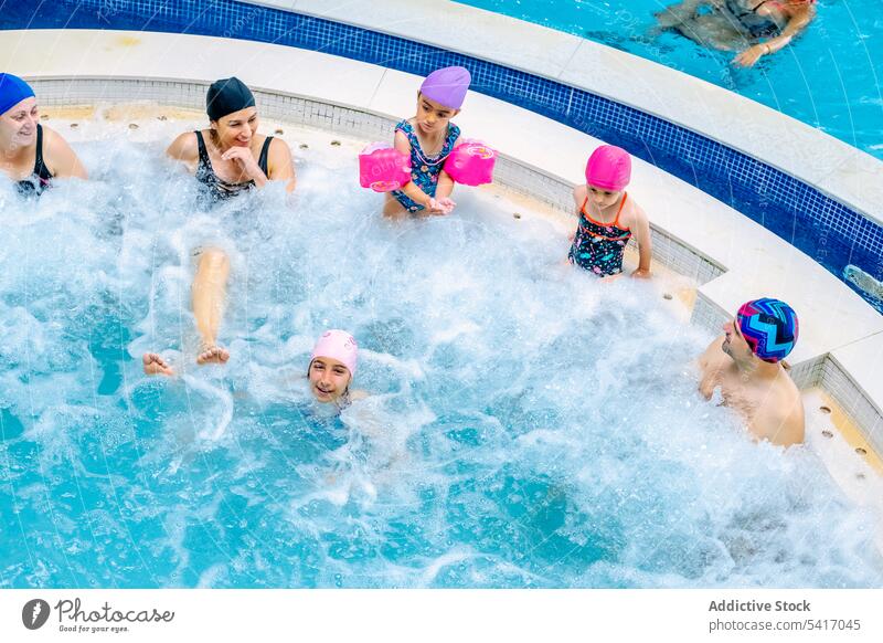 Familie entspannt im sprudelnden Pool Schwimmsport Blasen Eltern Töchter sprechend Zusammensein Vergnügen Park Wasser Spaß Freizeit ruhen sich[Akk] entspannen