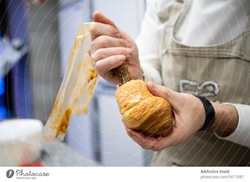 Konditor gießt Schokoladenfüllung in Croissant frisch Bäckerei Dessert Lebensmittel Gebäck Französisch traditionell Teigwaren Patisserie heiß geschmackvoll