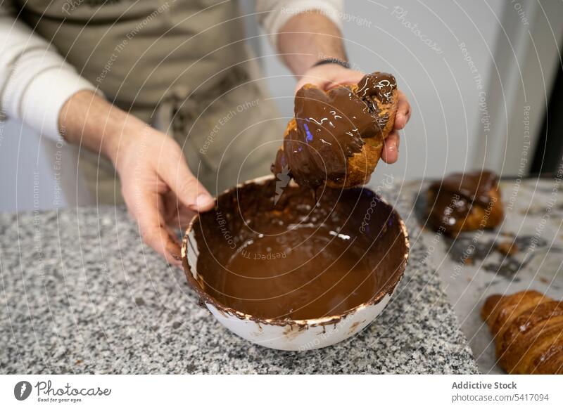 Konditor, der frisch gebackene Croissants verziert Mann eintauchend Schokolade Dessert dekorierend Essen zubereiten Küchenchef Beruf Arbeit männlich Erwachsener