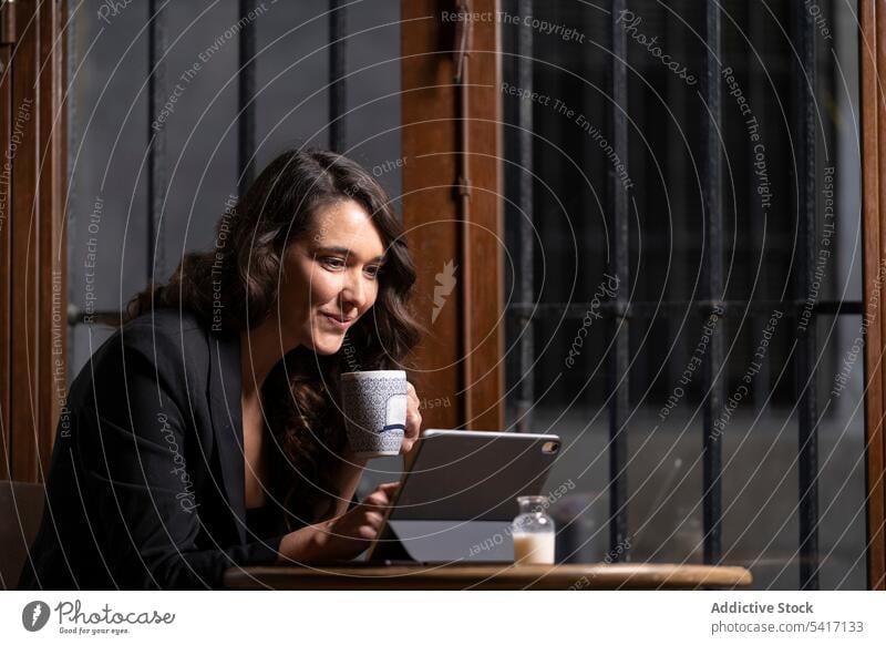 Junge Frau benutzt digitales Tablet in einem Café Tablette Tasse Browsen Technik & Technologie Tee Kaffee jung Person attraktiv brünett schön hübsch