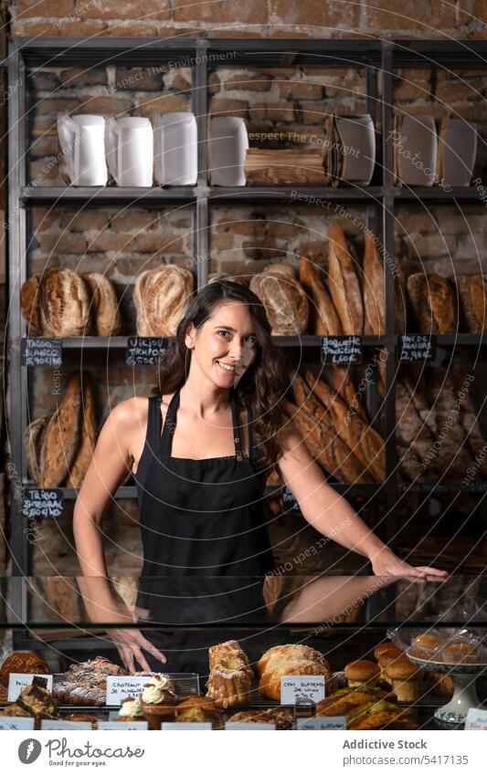 Junge Frau verkauft Baguette Bäckerei Brot Französisch traditionell frisch Lebensmittel Beruf Job jung Person schön attraktiv hübsch brünett Stehen arbeiten