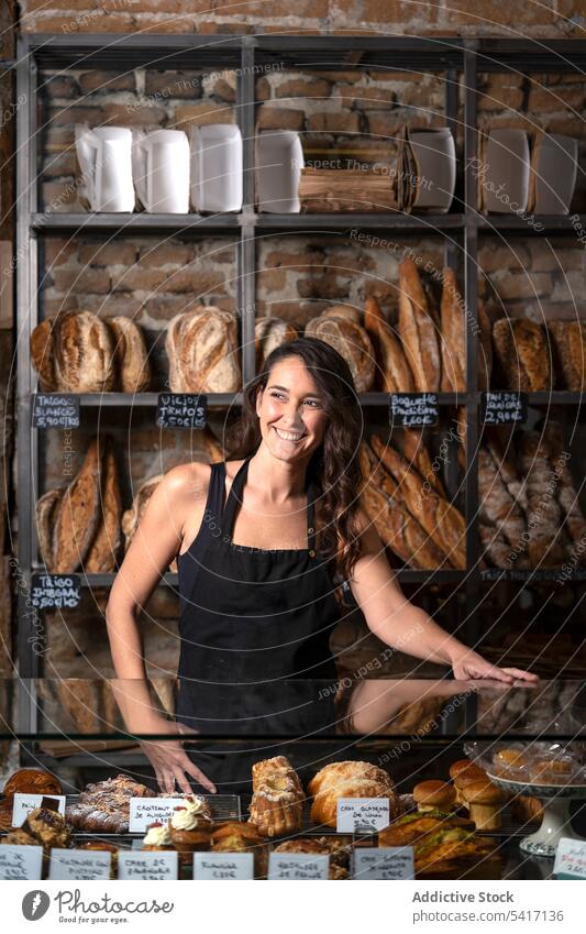 Junge Frau verkauft Baguette Bäckerei Brot Französisch traditionell frisch Lebensmittel Beruf Job jung Person schön attraktiv hübsch brünett Stehen arbeiten