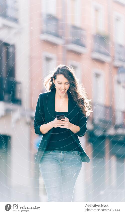 Junge Frau beim Spaziergang mit Smartphone Mobile Telefon laufen sprechend Mitteilung jung Person attraktiv brünett schön hübsch lange Haare lässig entspannt