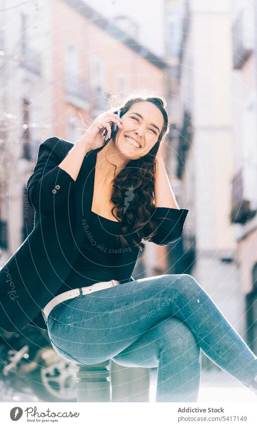 Junge Frau beim Spaziergang mit Smartphone Mobile Telefon Sitzen sprechend Mitteilung jung Person attraktiv brünett schön hübsch lange Haare lässig entspannt