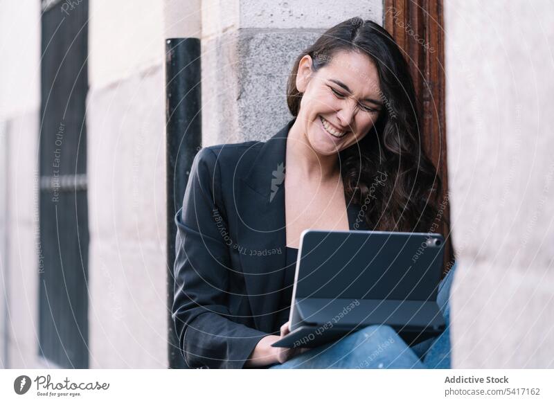 Junge Frau auf der Schwelle sitzend Tür Tablette Browsen Technik & Technologie jung Person attraktiv brünett schön hübsch lange Haare lässig modern stylisch