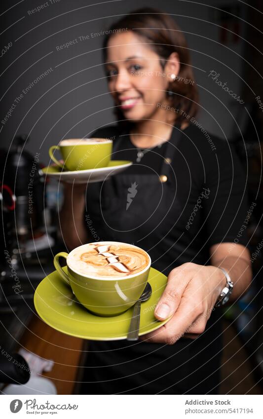 Ethnische Frau mit Cappuccinotassen Barista Latte Kunst Kaffee Café Beruf Job ethnisch Geben jung Person professionell heiter attraktiv Angebot schön positiv