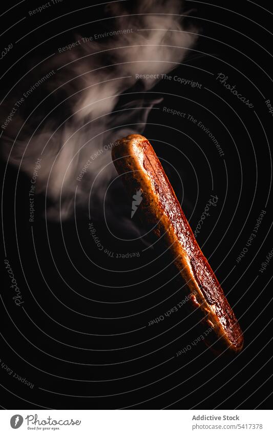 Rauch um leckere gegrillte Wurst in einem schwarzen Hintergrund Beschneidungspfad Mahlzeit Gastronomie ungesund Nahaufnahme gebraten Fleisch vorbereitet