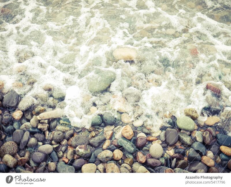 Meeresufer mit Kieselsteinen und Schaumstoff. abstrakt Hintergrund Strand schön Nahaufnahme Küste Dekoration & Verzierung ökologisch Umwelt schäumen Feiertage