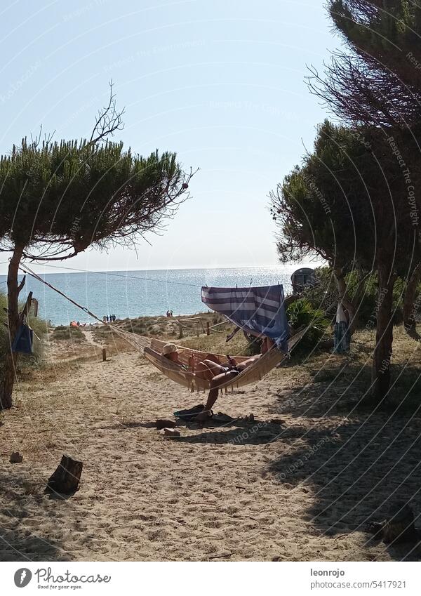 Ein Paar liegt gemütlich in einer Hängematte und genießt den Tag am Meer und Strand von Tarifa. Küste Sand Wasser Ferien & Urlaub & Reisen Außenaufnahme