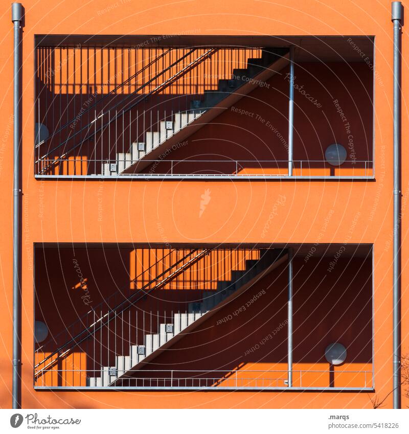 Treppe in orange Fassade Gebäude Schatten Architektur Bauwerk Schönes Wetter Sonnenlicht Treppengeländer Kontrast