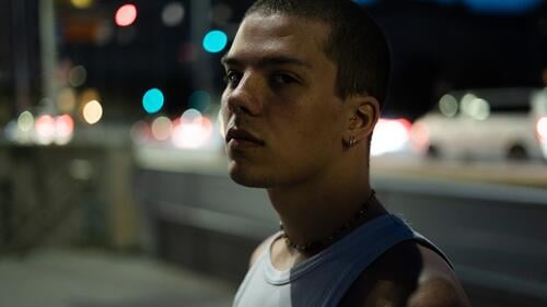 Portrait eines jungen Mannes nachts in der Stadt nachtspaziergang Straßenbeleuchtung trendy Blick streetstyle Street Photography urban nächtlich Gesicht