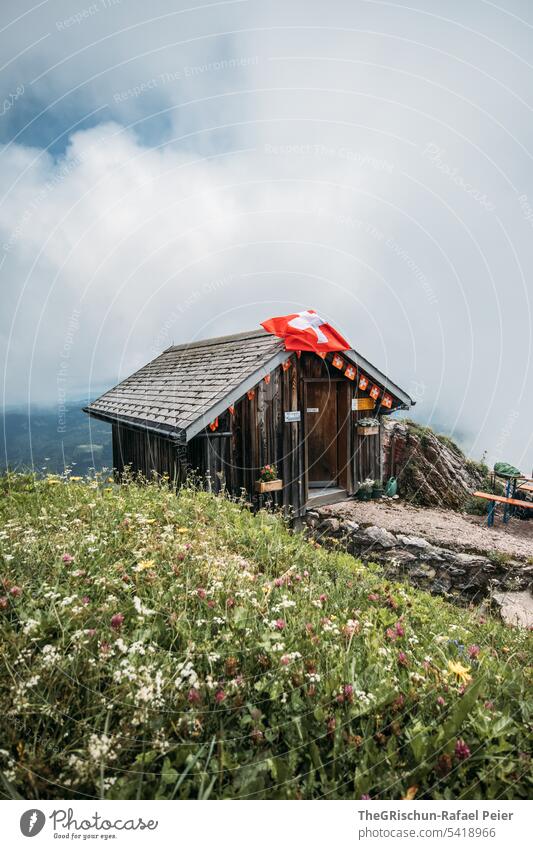 Haus mit Schweizerfahne vor Wolkigem Hintergrund Gras grosser Mythen Chalet schweizer fahne Fahne Tourismus Wiese Berge u. Gebirge Alpen Farbfoto wandern