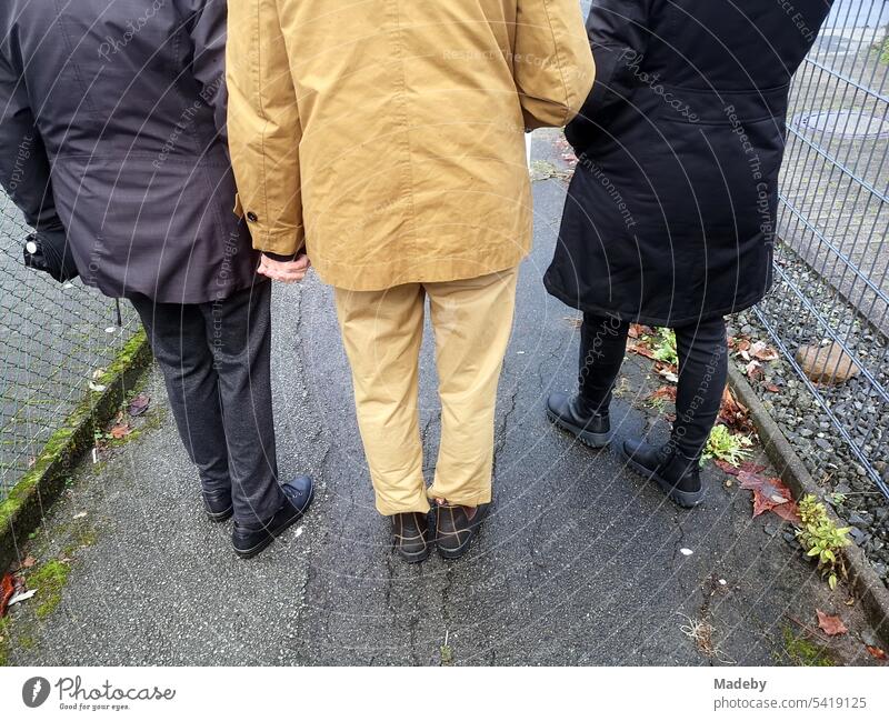 Frauen verschieden Alters mit Jacken und Mänteln in Beige ud Schwarz im beim Spaziergang auf nassem Asphalt in Oerlinghausen bei Bielefeld am Hermannsweg im Teutoburger Wald in Ostwestfalen-Lippe