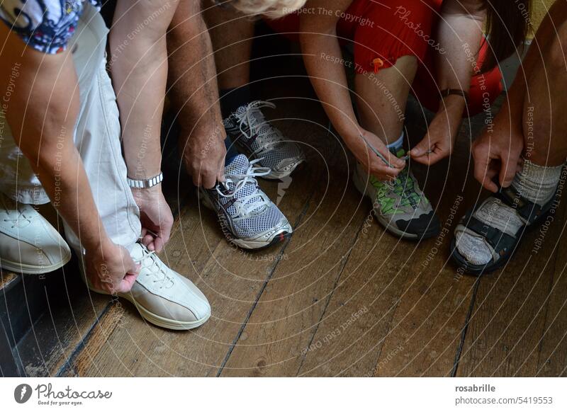auf gehts - Gruppe von Personen macht sich bereit und schnürt die Schuhe los auf die Plätze fertig los sich aufmachen starten schnüren Schuhe anziehen
