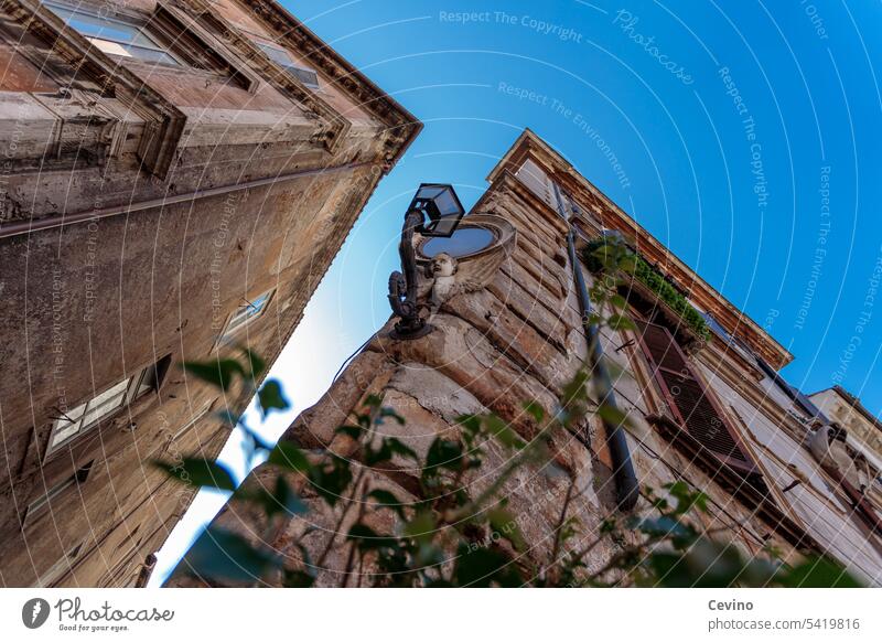 Hausecke in Rom Gasse Lampe Straßenbeleuchtung kitschig süß verspielt niedlich alt Altstadt Tourismus Sightseeing Blauer Himmel Wolkenloser Himmel enge Gasse