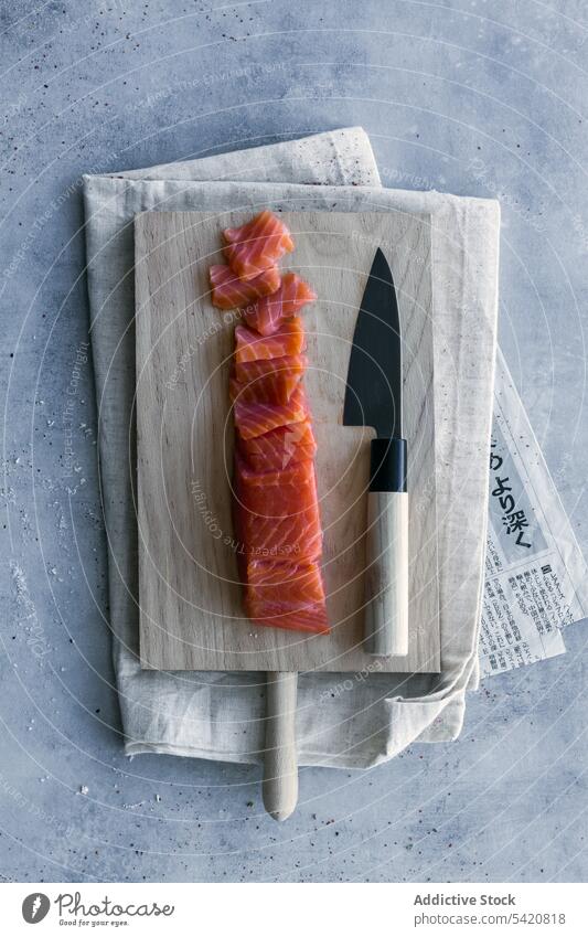 In Scheiben geschnittener roher Lachs auf einem Holzständer am servierten Tisch Sushi vorbereiten stoßen Schneidebrett Gesundheit Fisch Mahlzeit Mittagessen