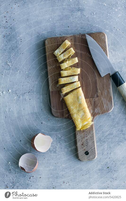 Aufgeschnittenes Omelett auf dem Schneidebrett auf dem Tisch frisch Ei rollen Lebensmittel Messer hölzern Eierschale Mahlzeit gebraten Frühstück Essen