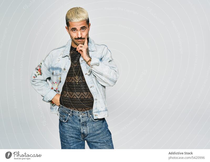 Stilvoller Grimassen schneidender Mann in Jeans-Outfit trendy unabhängig Jeansstoff expressiv modern Hipster ethnisch männlich Jacke Schnurrbart selbstbewusst