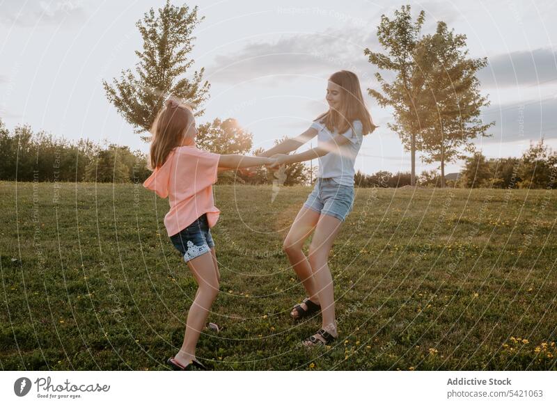 Glückliche Schwestern amüsieren sich im Sommer auf dem Land Kind Natur Zusammensein Spaß haben Mädchen Landschaft heiter laufen Teenager grün Wiese