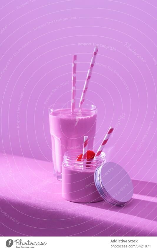 Leckerer Milchshake mit frischer reifer Erdbeere auf dem Tisch in rosa Licht Erdbeeren Molkerei trinken Gesundheit Diät Supernahrung Erfrischung Vitamin Glas