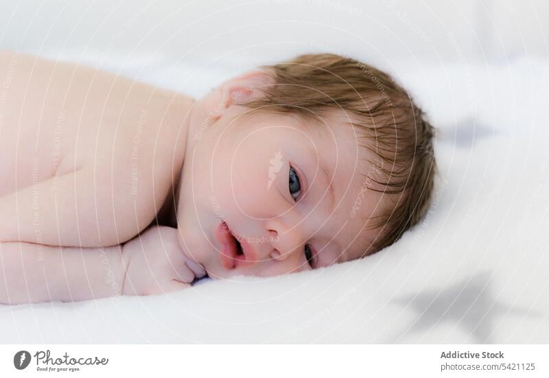Niedliches Baby in Decke auf dem Bett liegend neugeboren bezaubernd Kind Lügen umhüllen Porträt winzig rosa süß wenig Säugling Kindheit Kinderbetreuung
