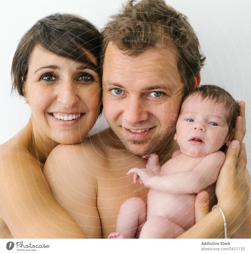 Glückliche Familie mit neugeborenem Baby Liebe Zusammensein Umarmen Lächeln Partnerschaft Porträt Mutter Vater positiv jung Kind Umarmung kuscheln Papa Mama