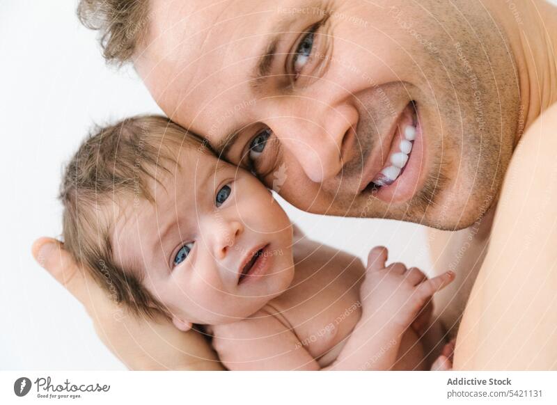 Glücklicher Vater mit kleinem Baby neugeboren Mann Liebe Eltern Umarmen kuscheln Porträt heiter männlich Kind Umarmung Lächeln Papa Zusammensein süß wenig