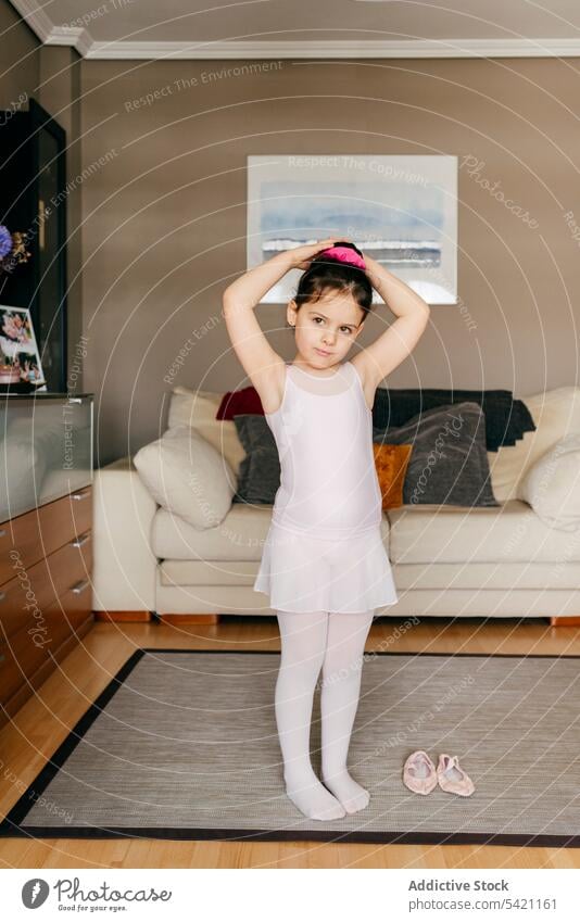 Kleines Mädchen bereitet sich zu Hause auf eine Ballettprobe vor Ballerina vorbereiten Probe heimwärts Haarknoten Trikot Wohnzimmer Balletttänzer wenig Tänzer