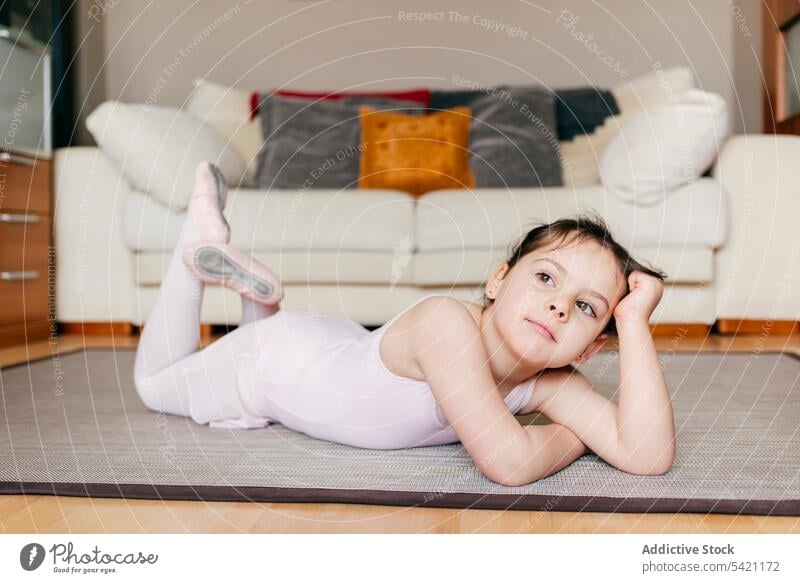 Gelangweilte kleine Ballerina auf dem Boden liegend Mädchen gelangweilt Probe Pause Lügen Stock heimwärts wenig Wohnzimmer Balletttänzer Kind Trikot