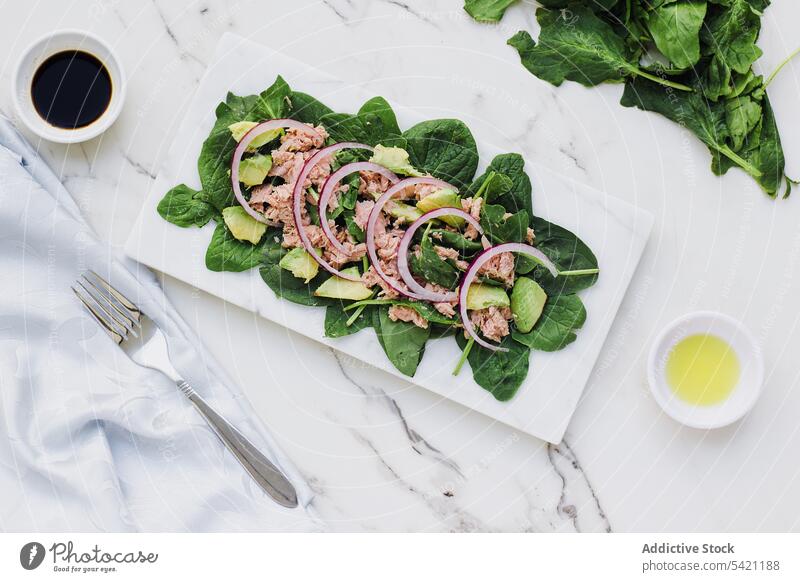 Leckerer Salat mit Thunfisch und frischem Grün auf dem Marmortisch Salatbeilage Avocado Zwiebel lecker Gesundheit Spinat Murmel Tisch Abendessen Gemüse